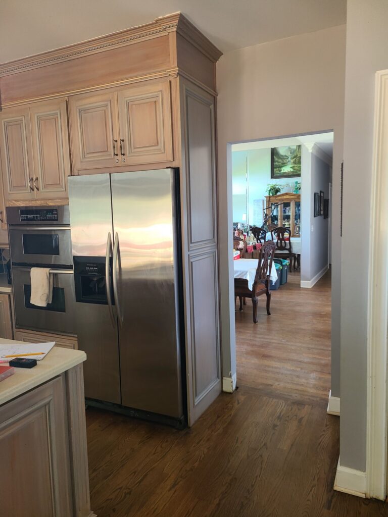 Original kitchen with side-by-side refrigerator and wall ovens