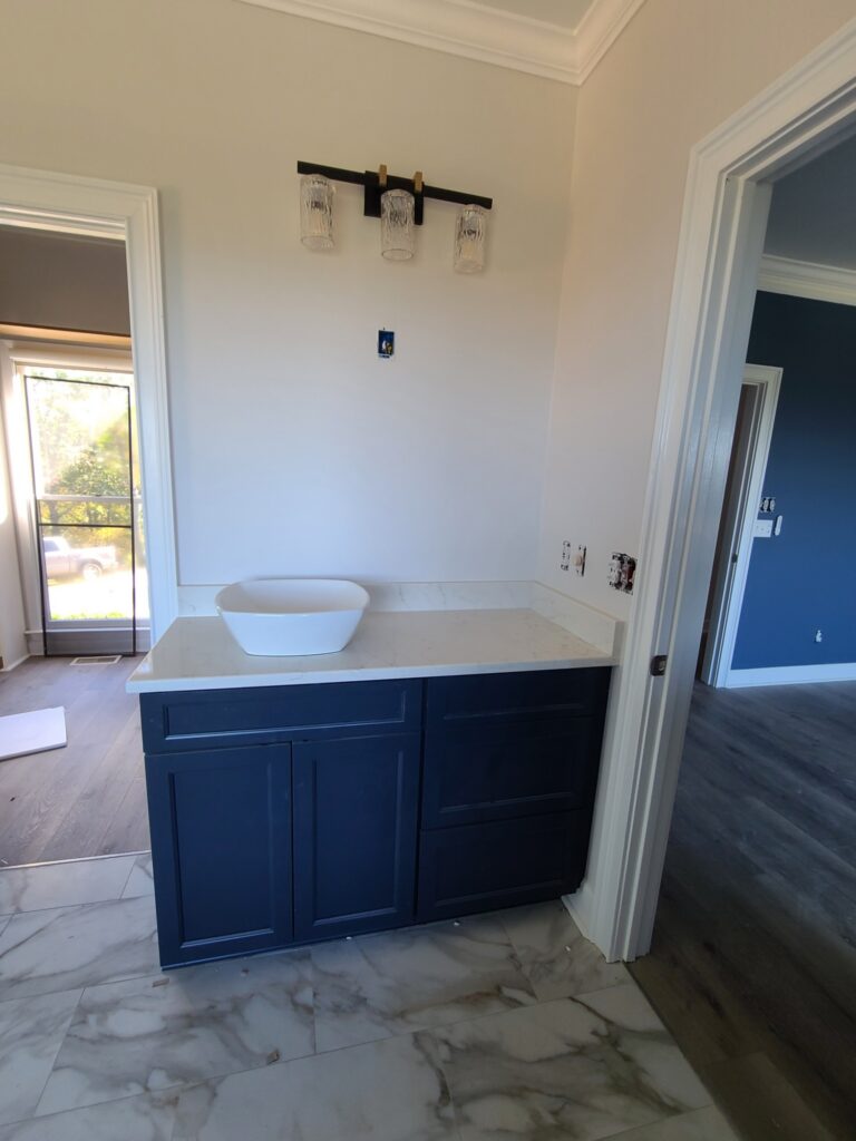 Navy vanity with vessel sink and glass light fixture