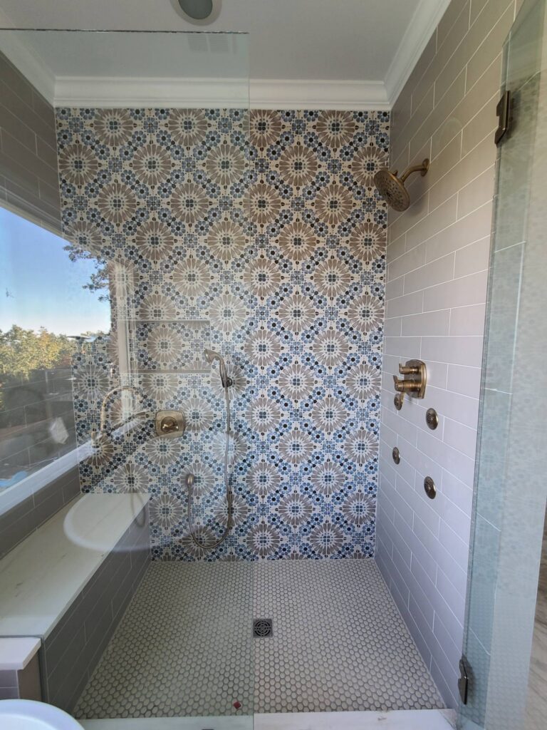 Primary shower with blue and taupe patterned tile wall