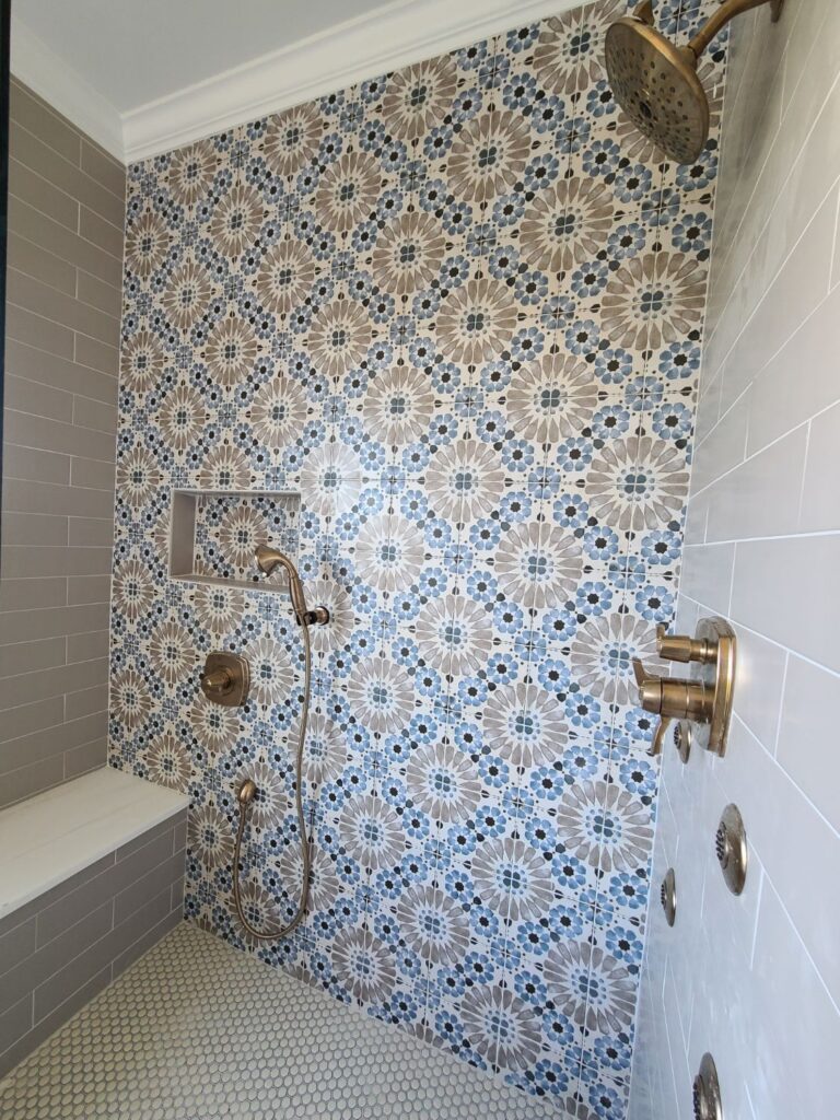 Patterned shower wall with bench and brass fixtures