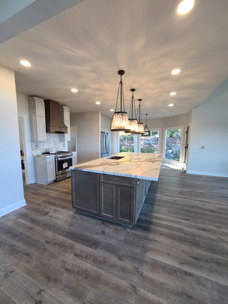 New kitchen with oversized island and wood range hood