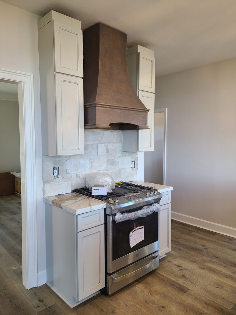 Range with wood hood and stone backsplash
