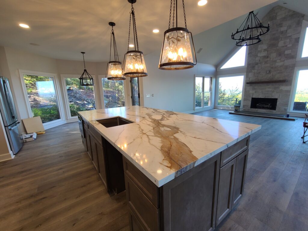 Open kitchen island looking toward the stone fireplace and mountain views